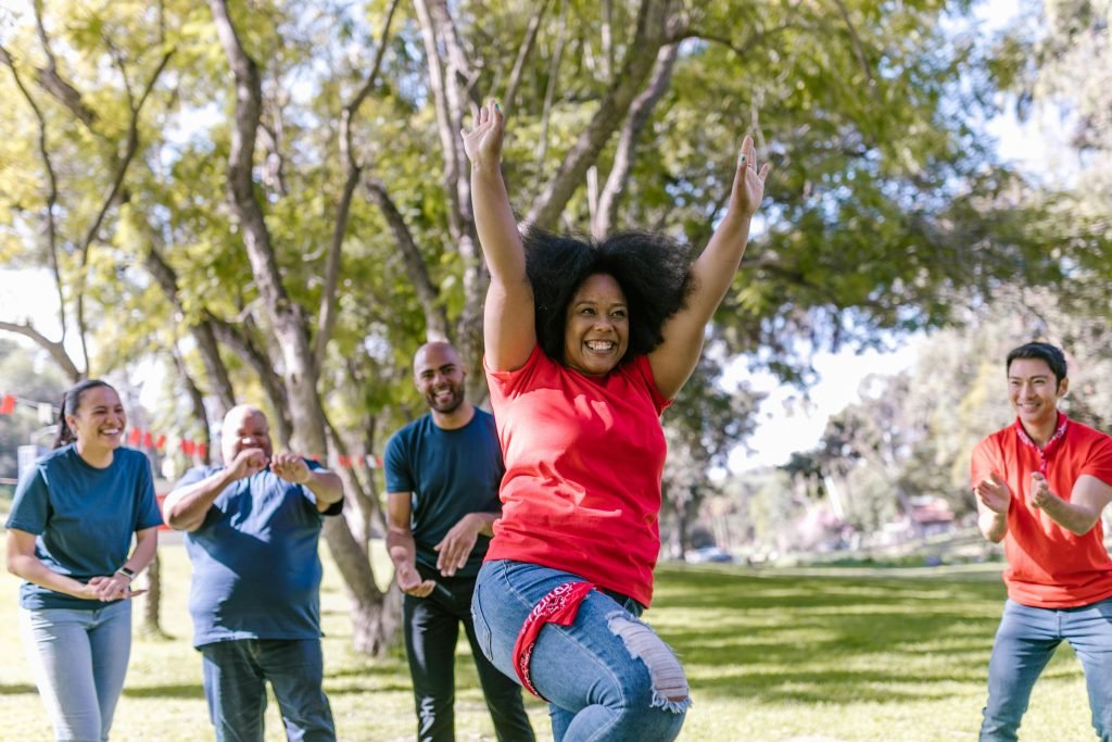 Diverse group enjoying a lively outdoor team-building exercise in a sunny park.